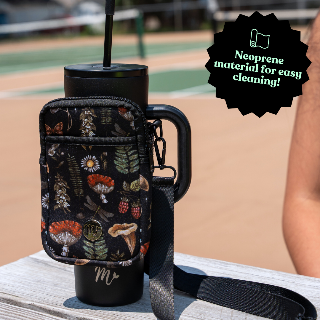 "30 oz Black Tumbler with Nature-Inspired Sling - Showcasing a neoprene pouch for easy cleaning, adorned with a nature-inspired design featuring mushrooms, ferns, and berries. The sling is perfect for outdoor enthusiasts, providing both style and functionality with an adjustable strap and secure fit for carrying essentials.